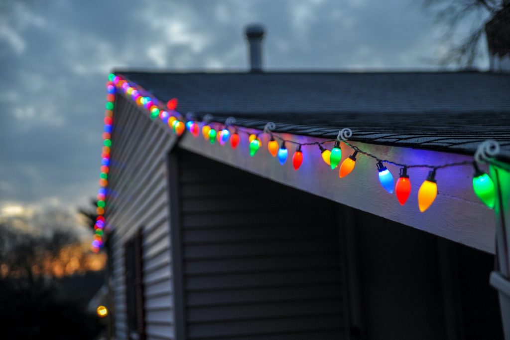 Grey house with coloured string of Christmas lights
