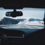 Image of two people in a moving vehicle on a snowy highway