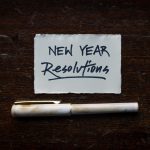 Image of a white piece of paper on a table with the words "New Year Resolutions"